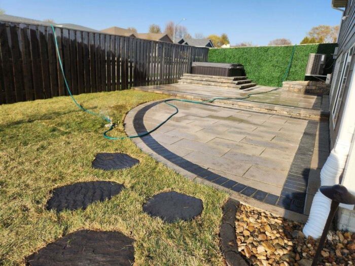 Paver Patio with steps up to hot tub and outdoor lighting after photo of paver patio with steps to hot tub landscaping project